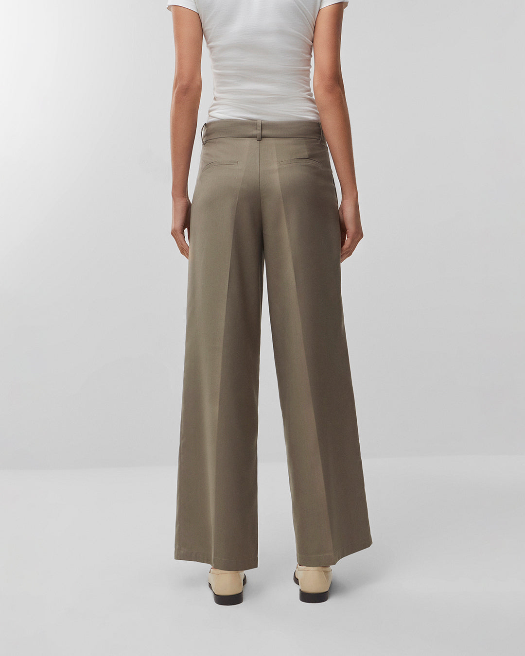 Calça wide leg alfaiataria areia – modelo pose sentada editorial
